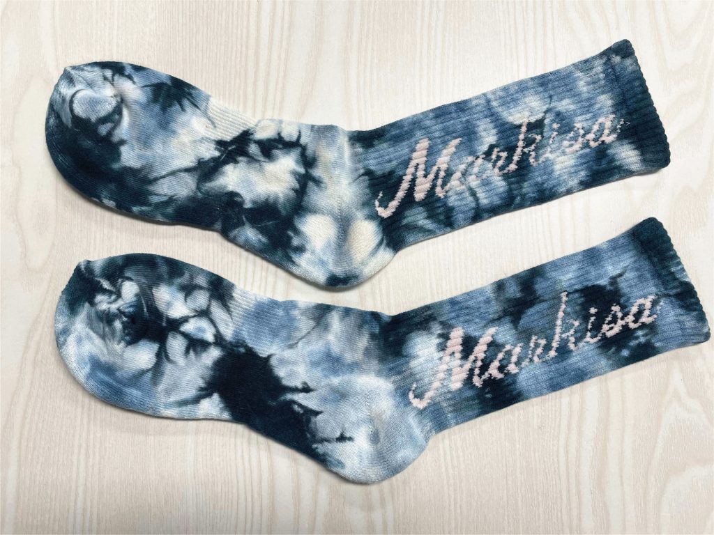 Max Hosiery's correct sock measurement shown on a pair of tie-dye socks.
