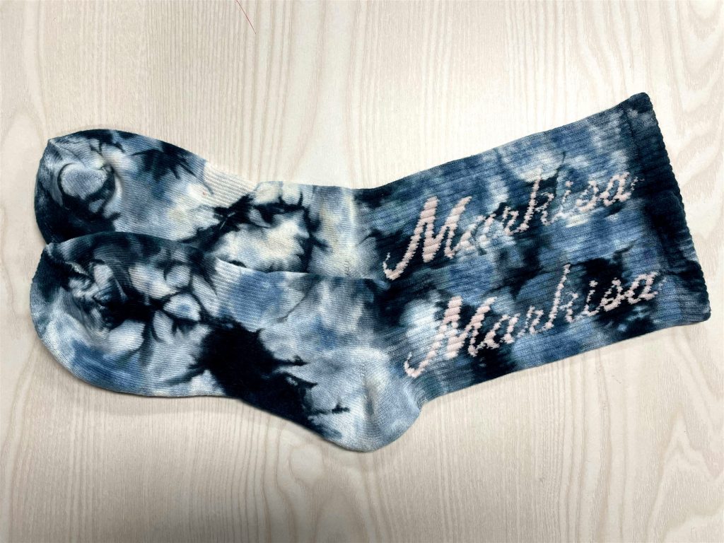 Wrong socks measure method exemplified by tie-dye socks with a printed name.
