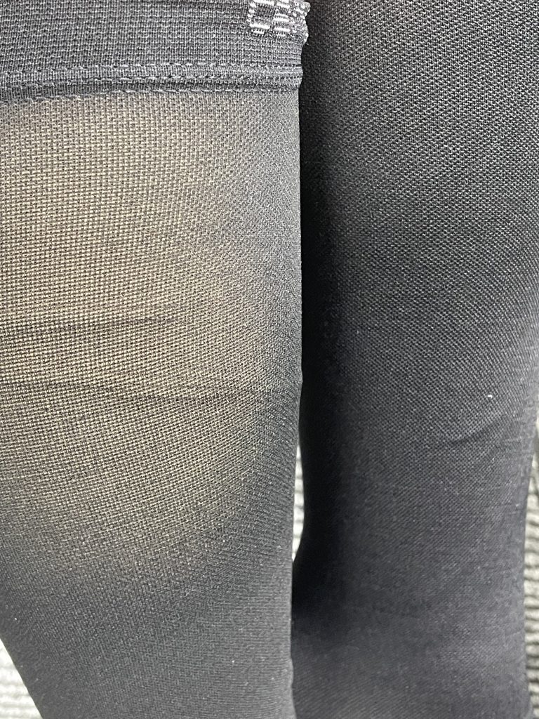 See through black socks showing fabric sheerness on a leg.