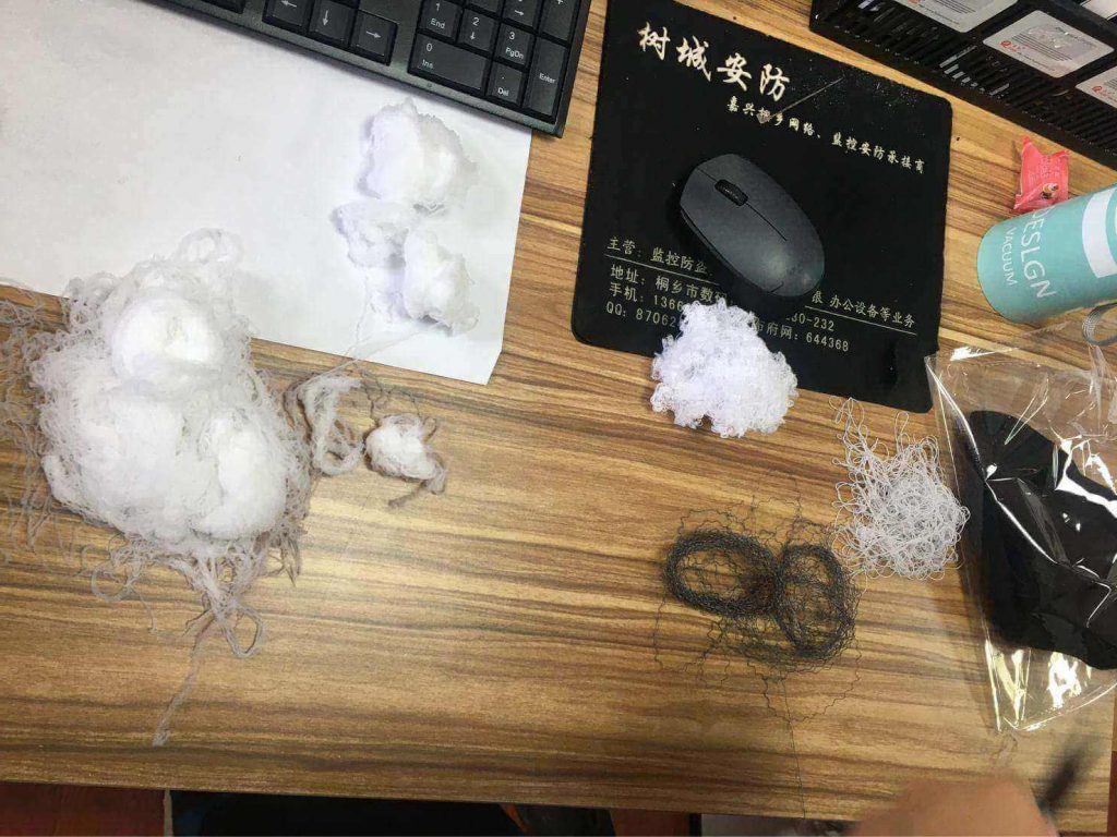 Composition of socks, with various fibers including white fluff and dark threads.