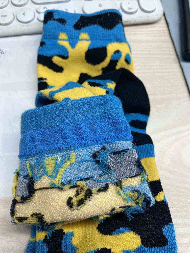 Blue and yellow camouflage socks showing the yarn inside construction.