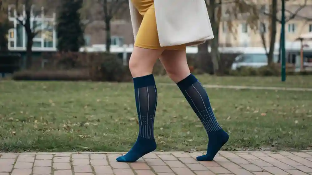Compression socks for pregnant women worn by a woman walking outdoors.