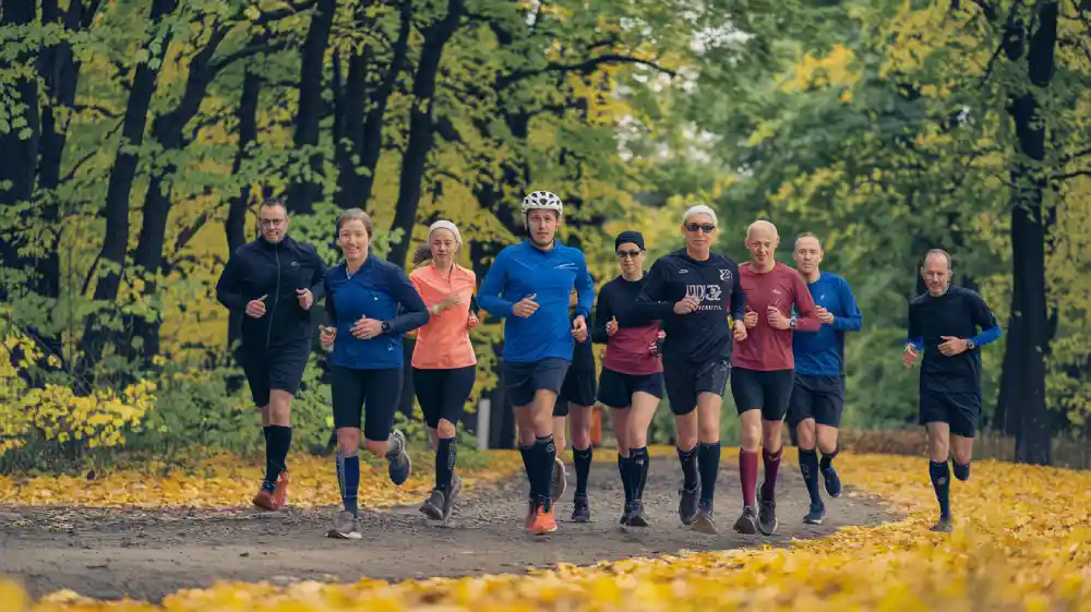 running compression socks for a group of people jogging in an autumn park
