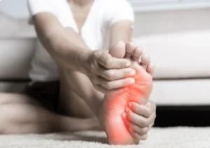 A person experiencing foot pain, potentially needing neuropathy-socks-scaled for comfort.