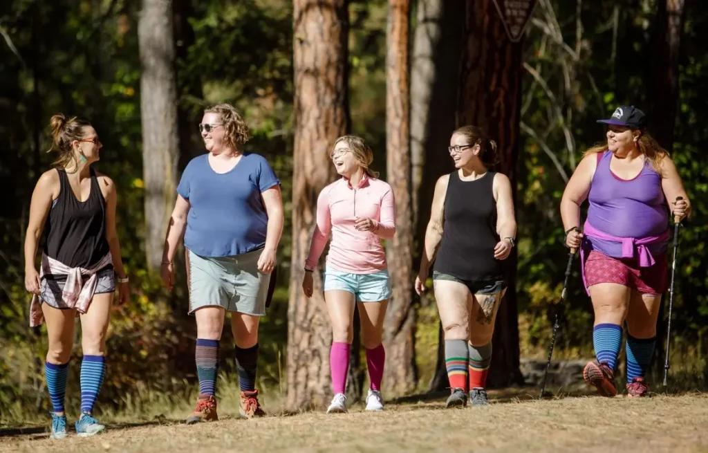 Group of women walking with compression socks in a forest.