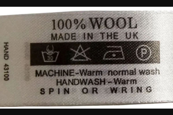 Close up of care label showing cold wash and low heat drying instructions to prevent shrinkage