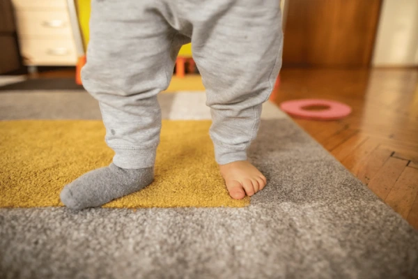 Comparison of toddler barefoot, wearing grip socks, slippers, and baby shoes on different surfaces
