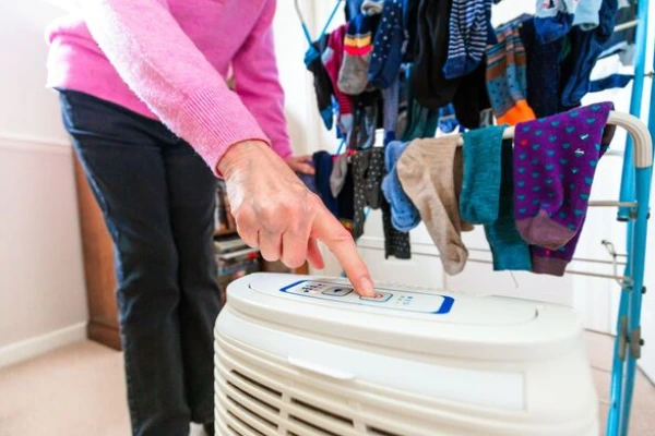 Dehumidifier and fan speeding up wool sock drying in a humid room