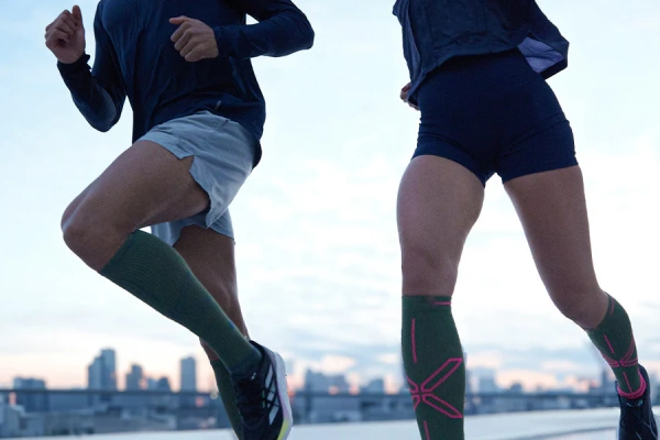 Runner putting on moisture wicking running socks before training, illustrating comfort and performance benefits