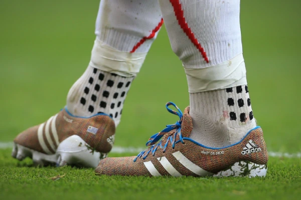 A close-up of a football player's dirty football socks and cleats after a game.