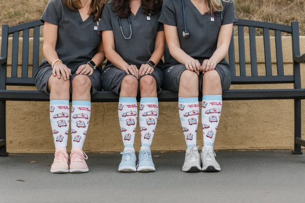 Women’s striped floral compression socks styled with matching shoes and bag