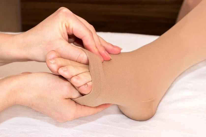 Neuropathy socks for foot pain being applied to foot