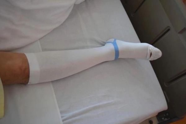 Patient resting after surgery wearing compression socks to support recovery and blood flow
