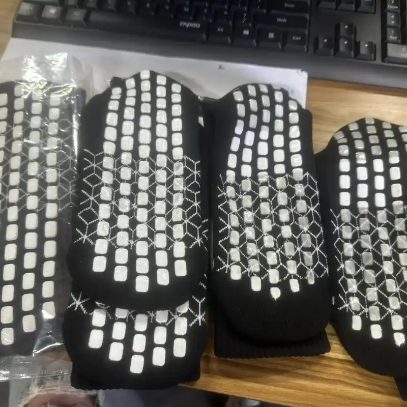 Grip socks black fabric with white silicone grids showing bleeding and smearing defects