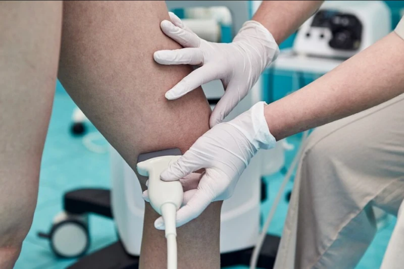 Doctor examining leg circulation with ultrasound