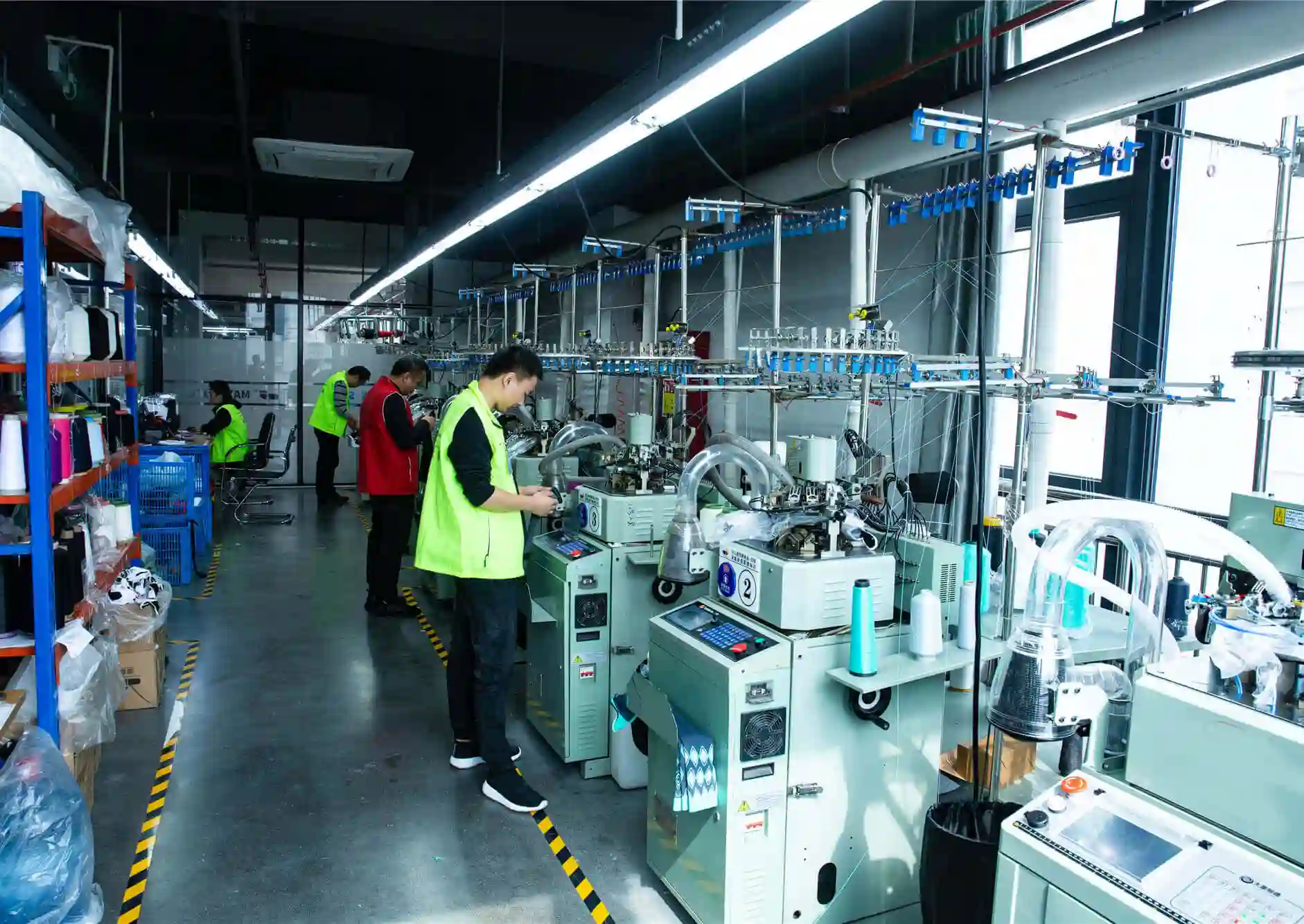 Sampling workers operating circular knitting machines in sock factory
