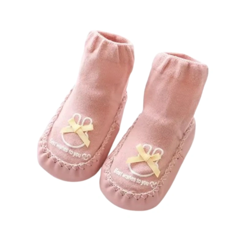 Pink toddler slipper socks with a rabbit face and a yellow bow.