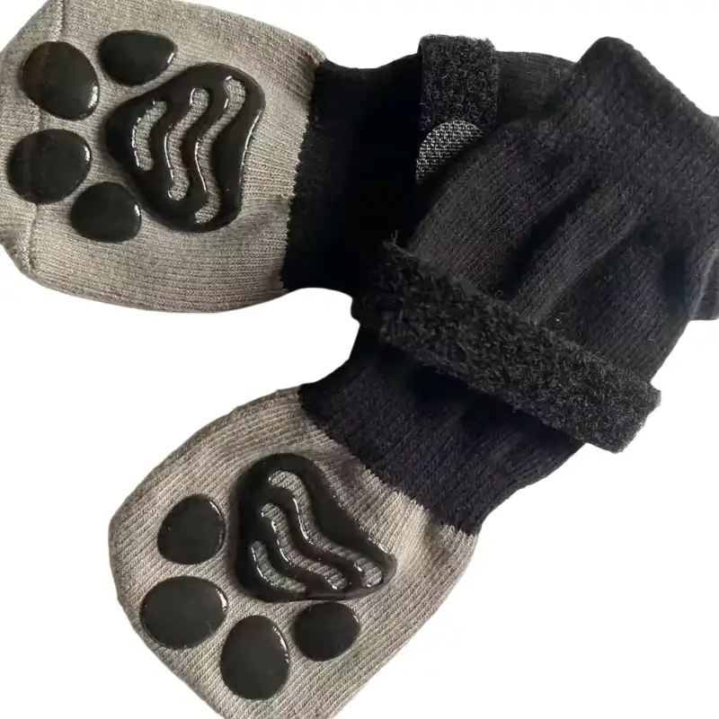 A pair of grey and black dog anti-slip socks with paw-shaped grips on the bottom.