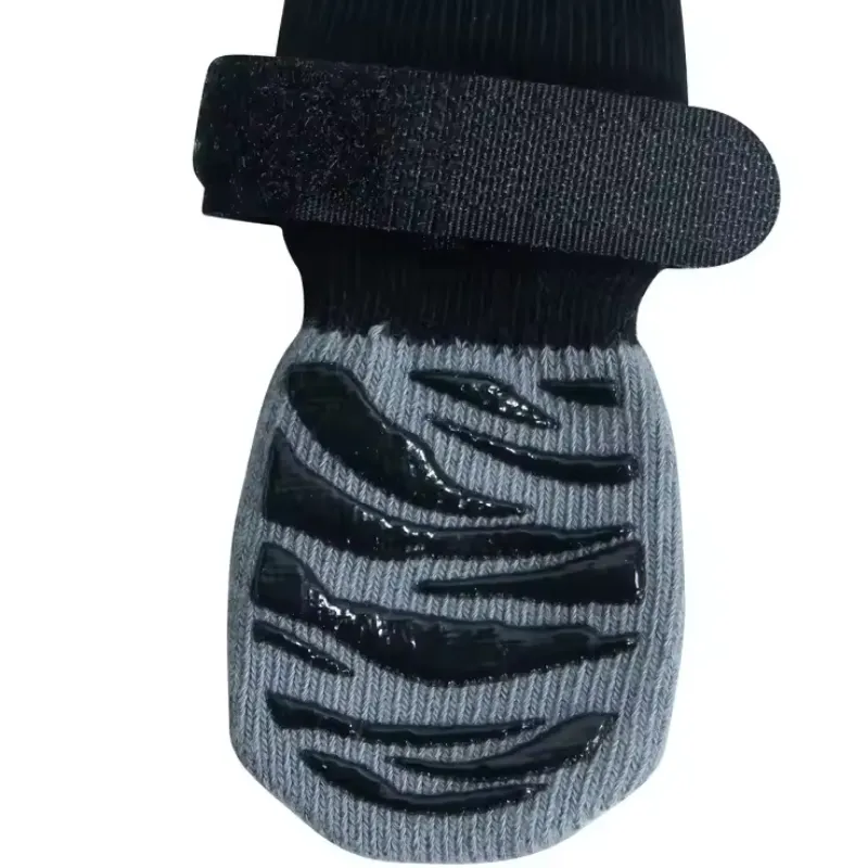 Gray and black non-slip dog socks with textured paw grips and a secure hook-and-loop strap.