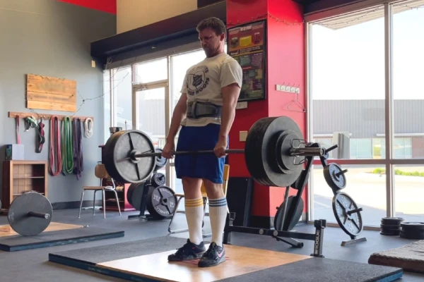 Weightlifter wearing deadlift socks prepares for a heavy lift in a gym.