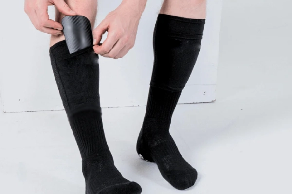 Shin pad sleeves with pouch for securing protective gear