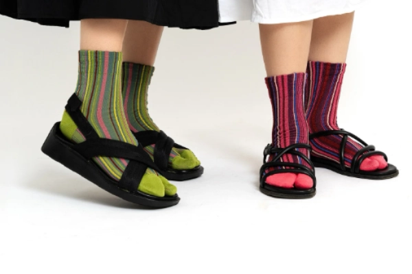 Tabi socks with vibrant stripes and black toe-post sandals