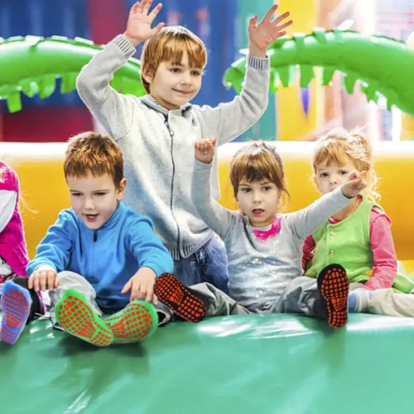 a group of happy kids wearing anti-slip trampoline socks on an indoor playground