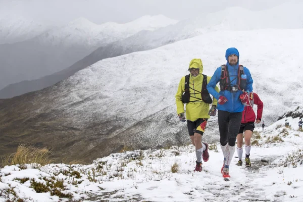 Runner’s feet in winter running socks on a snowy path, illustrating the importance of proper cold weather gear to keep feet warm and dry