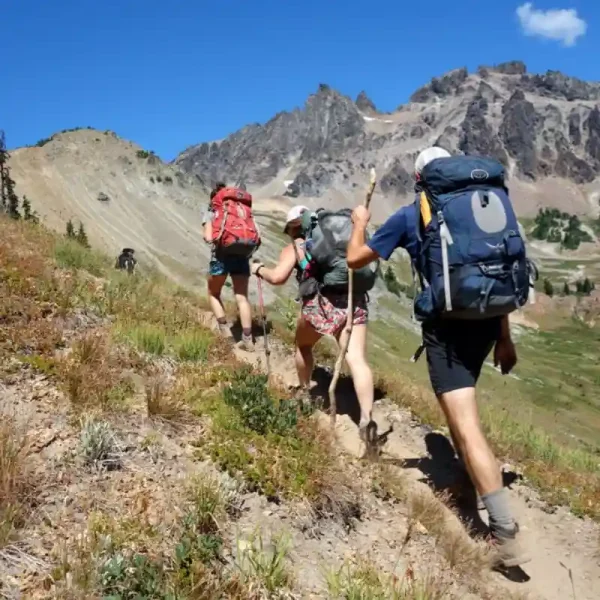 People wear merino wool hiking socks while ascending a mountain trail