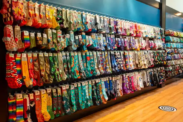 A colorful wall display of various printed socks in a retail store
