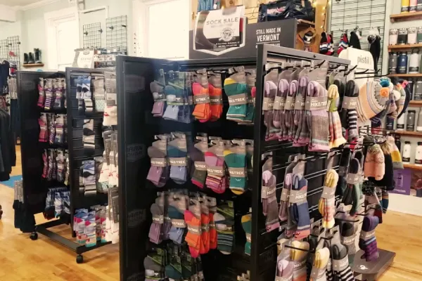 A large display of colorful ski and snowboard socks in a retail store.