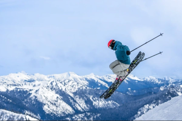 Freestyle skier landing a jump in terrain park wearing ski boots – demonstrates impact and need for shock absorbing socks