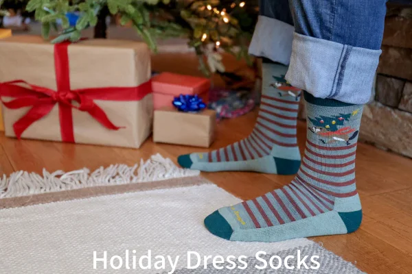 A person in festive Holiday dress socks standing near Christmas gifts