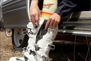 Motocross rider adjusting knee high padded socks inside mx boots