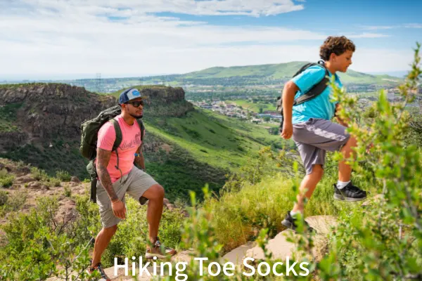 Father and son hike uphill, showing the durability and comfort of hiking toe socks
