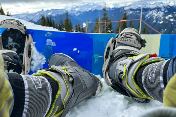 Imfreestyle skier tightening ski boots with over the calf socks visible, showing proper sock and boot fit harmony