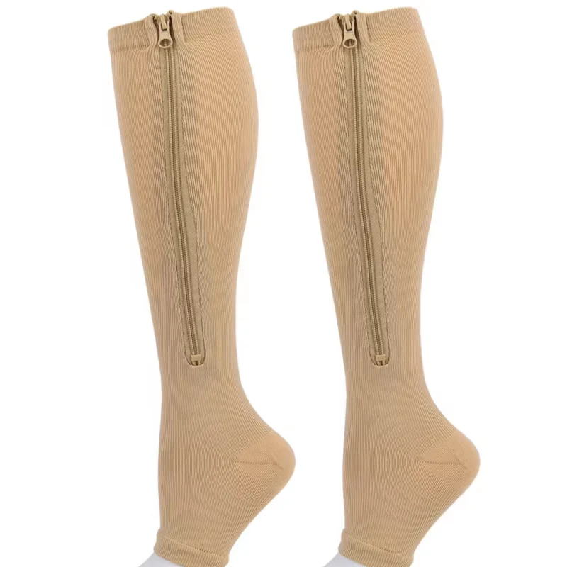 pair of beige ribbed open toe compression socks with zipper shown on a white background