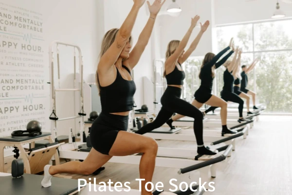 Woman in foreground lunges on reformer during Toe socks pilates class
