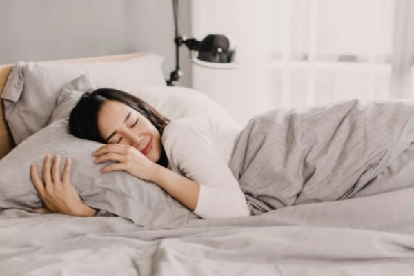 Woman resting comfortably in bed illustrating plantar fasciitis socks for recovery