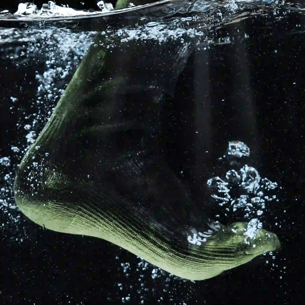 Waterproof wudu sock submerged in water demonstrating full liquid resistance and breathable membrane performance