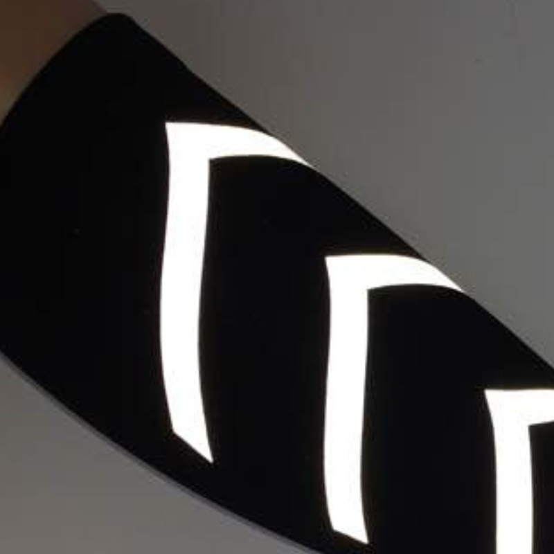 Detail of black calf compression sleeve showing horizontal striped reflective elements integrated into the knit