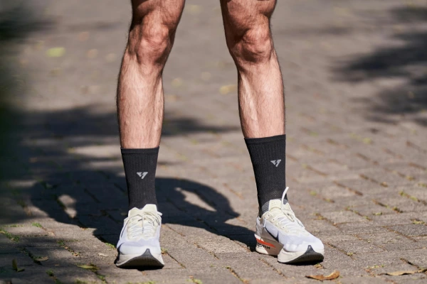 Running socks with athletic shoes showing a more structured fit than tube socks
