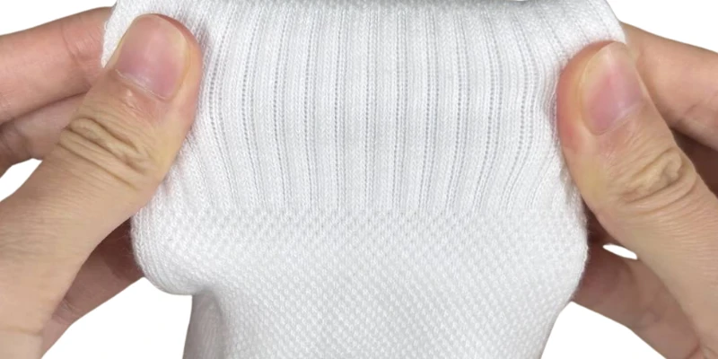 High-density elastic compression arch band stretched to show the midfoot knit that locks the sock to the foot