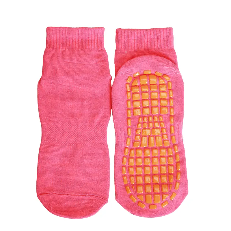 Pair of pink ankle trampoline socks with orange non-slip grip sole