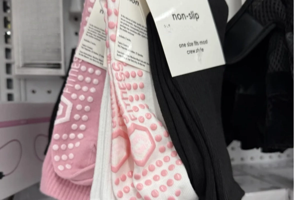 Packaged pink and black non-slip grip socks on retail display