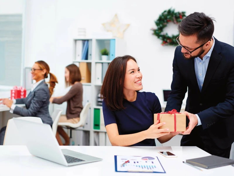 Businessman presenting a packaged gift box containing dress socks for corporate gift programs