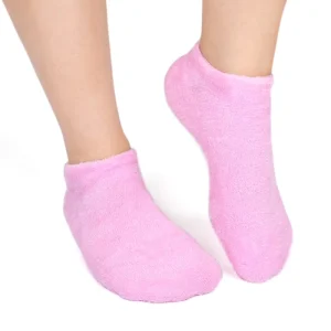 Spa gel socks being worn on feet for a moisturizing pink fuzzy treatment