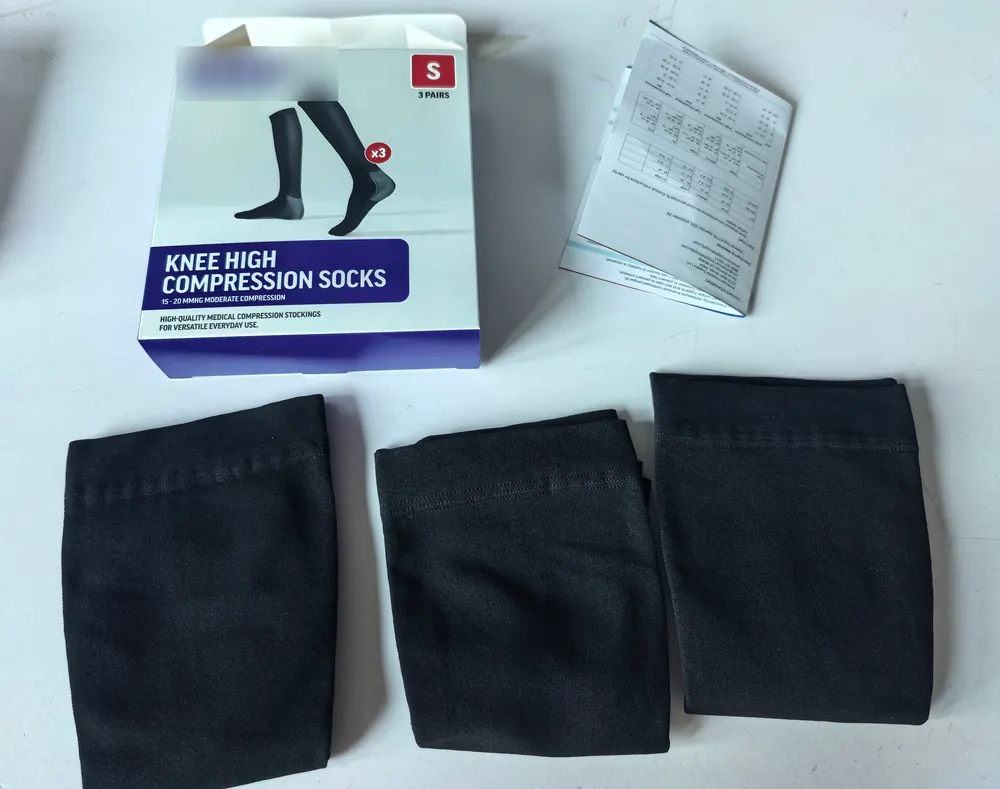 Compression socks retail box, instructions for use leaflet and three black knee-high socks