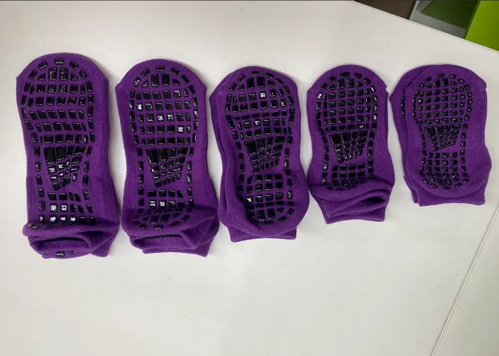 Original photograph of five trampoline sock sample soles showing the grip layout