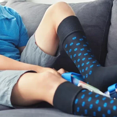 Child wearing knee-high blue polka dot compression socks